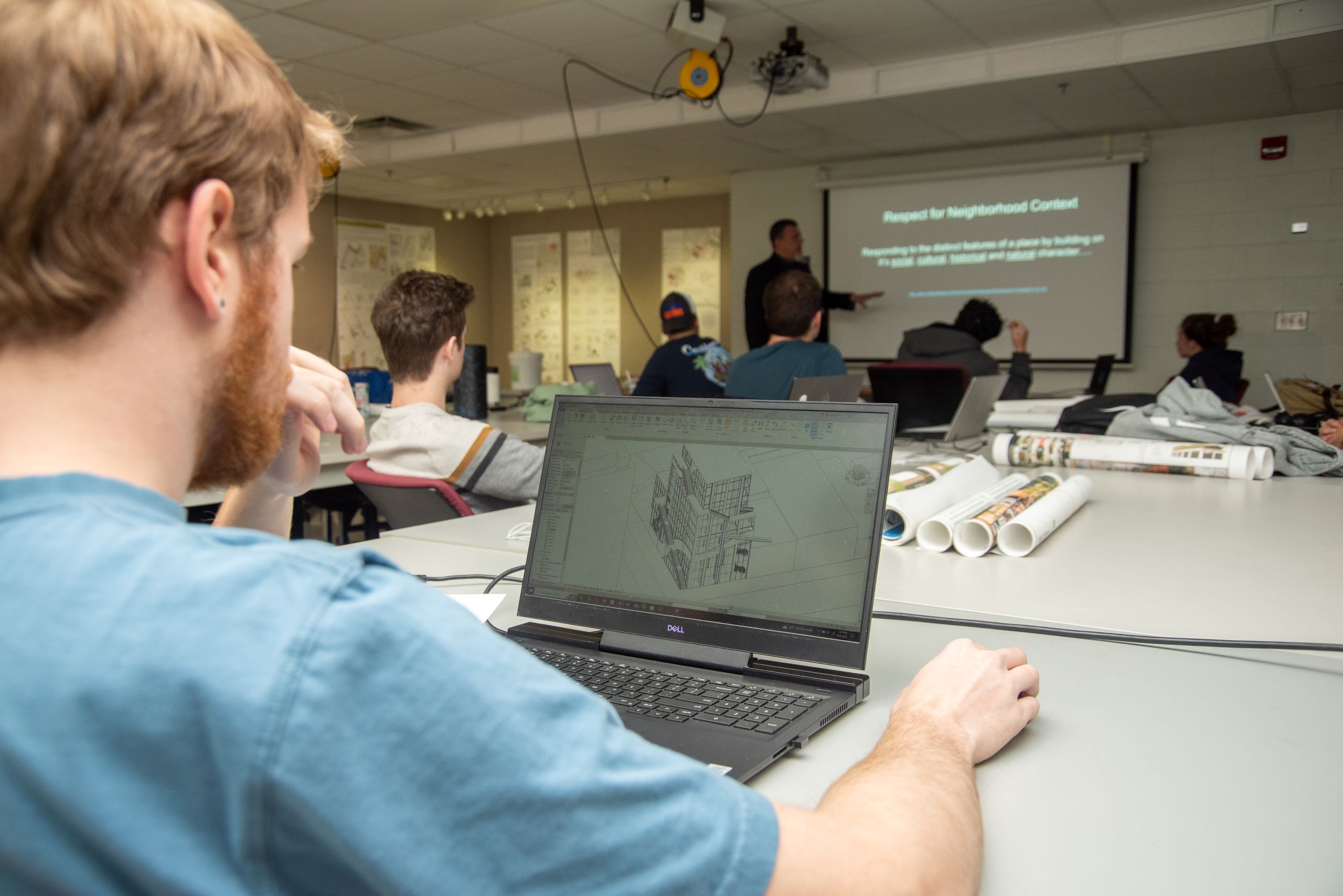 A student uses a laptop displaying a drafting program during a presentation in a classroom at a Western New York Works college.
