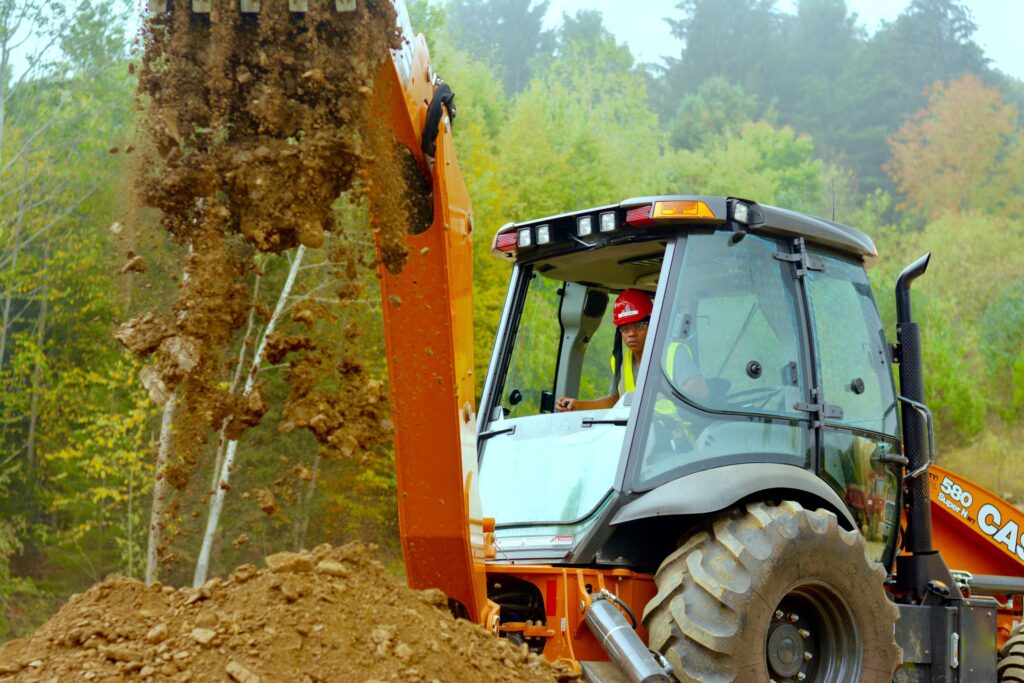 A student wearing a hard hat operates an excavator in a heavy equipment class for a construction career training program at a Western New York Works college.