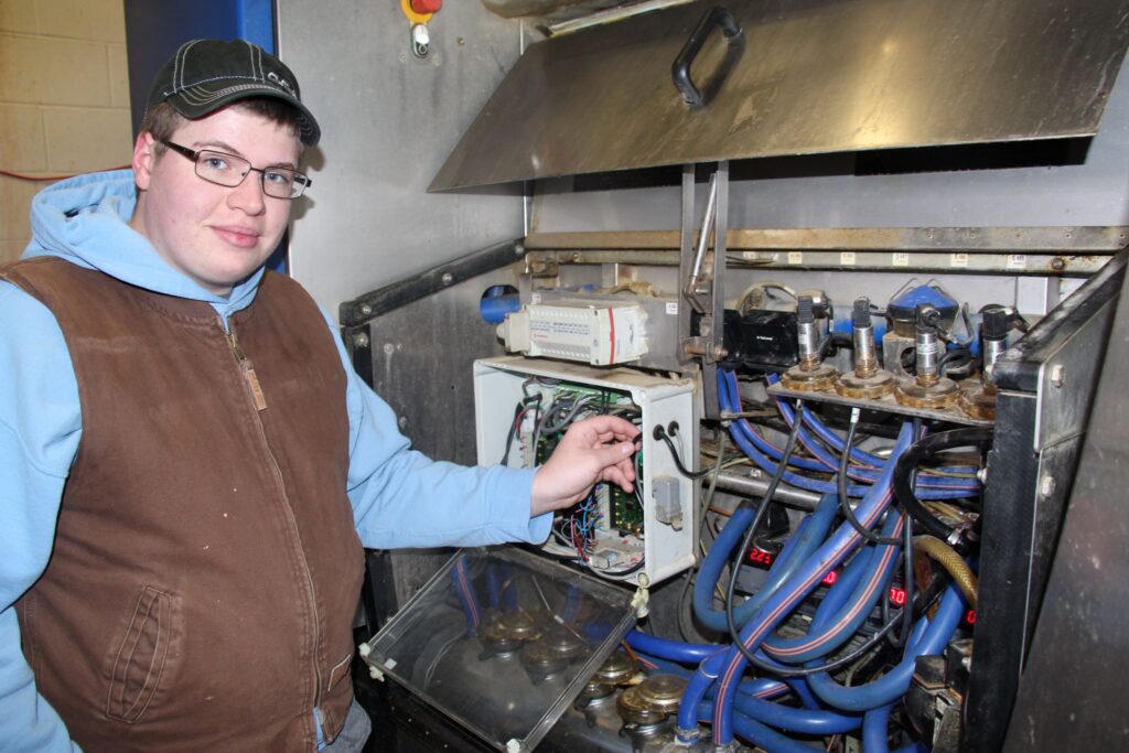A male student gets practice using agricultural industrial equipment in a career training program at a Western New York Works college.